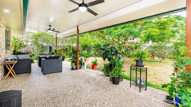 An outdoor patio with a ceiling fan, seating area, and potted plants. - Delightful Duplex on Rose (BONGAREE)