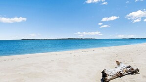 A beach with clear blue water and a sandy shore. - Delightful Duplex on Rose (BONGAREE)