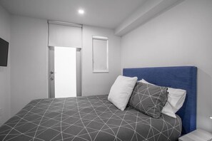 A bedroom with a bed, a door, and a window. - Lux 2-Bedroom w/ Parking – 6 Blocks from Lincoln Rd (Miami Beach)