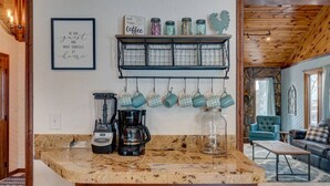 A kitchen with a coffee maker, blender, and jars on a shelf. - Theater Room | Hot Tub | Arcades | Great Location! (Spearfish)