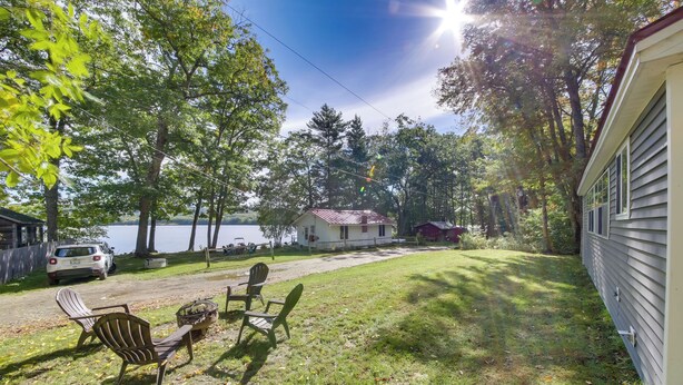 A grassy yard with a small table and chairs, a house, and a lake in the background. - Rustic Retreat Across from Lake; Family Friendly! (Union)