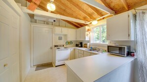 A kitchen with white cabinets, a microwave, and a stove. - Rustic Retreat Across from Lake; Family Friendly! (Union)