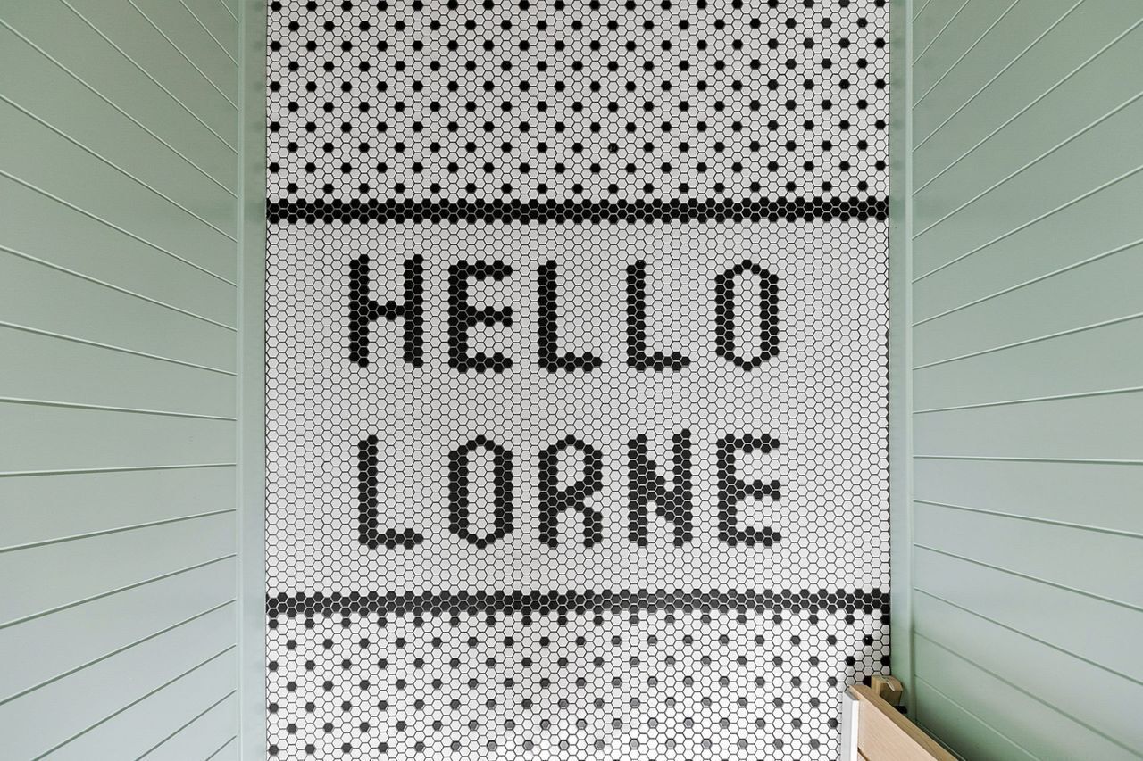A wall with a hexagonal pattern and the words 'HELLO LORNE' in black.