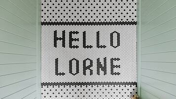 A wall with a hexagonal pattern and the words 'HELLO LORNE' in black.