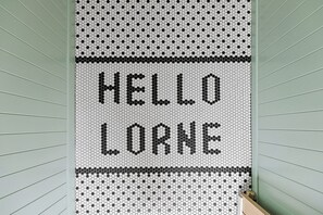 A wall with a hexagonal pattern and the words 'HELLO LORNE' in black.