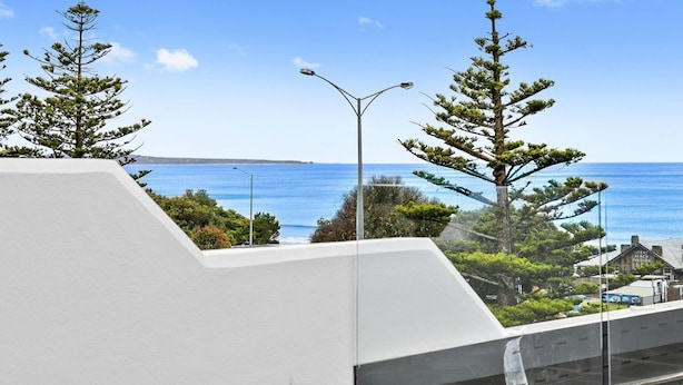 Un edificio moderno con vista al mar, una farola y un cartel que dice 'Lorny's Pavilion'.