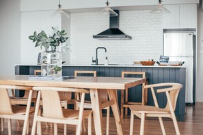 Una cocina moderna con una isla central, sillas de madera y una mesa de comedor.