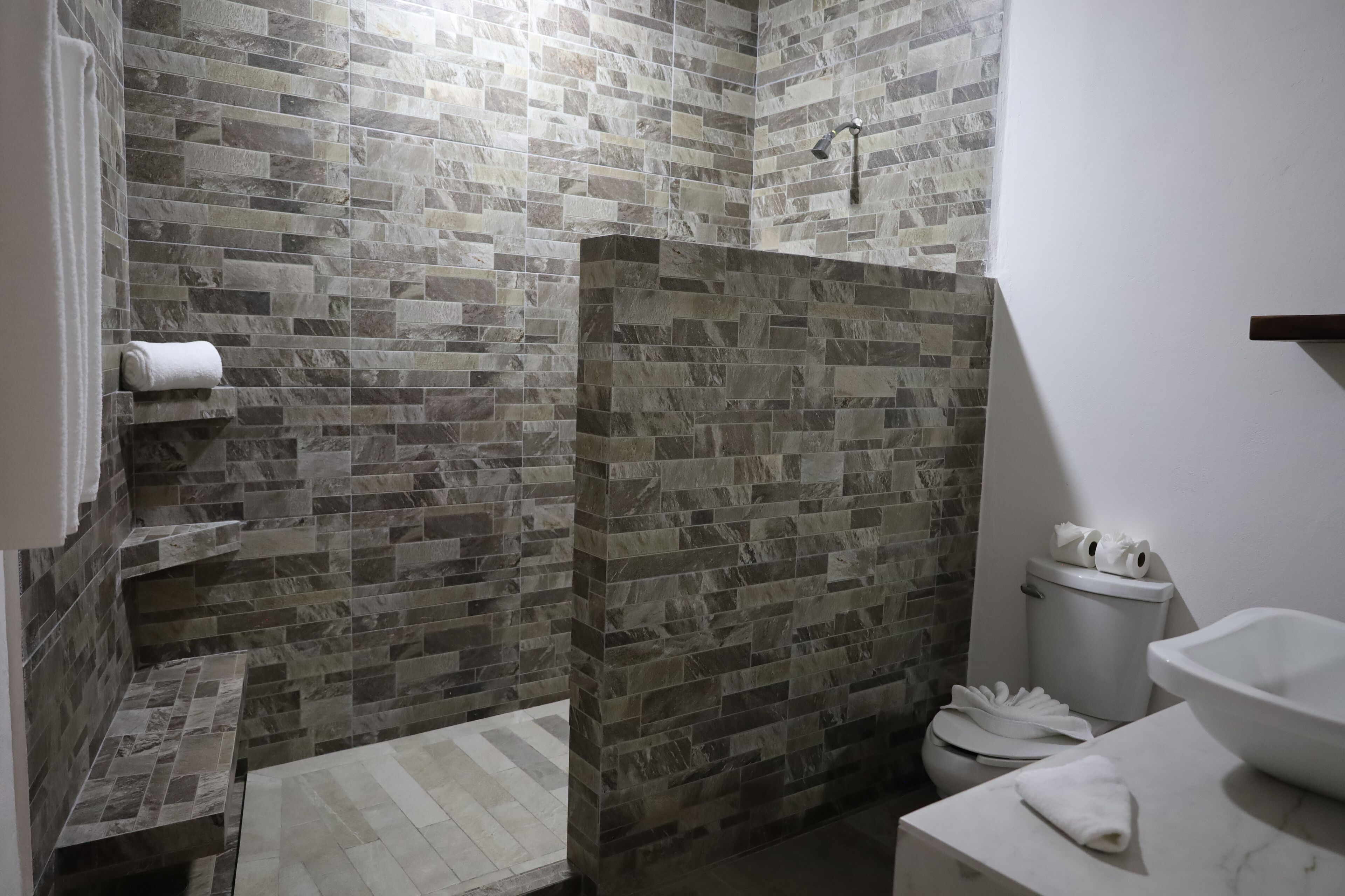 Ein Badezimmer mit Dusche, Toilette und Waschbecken.