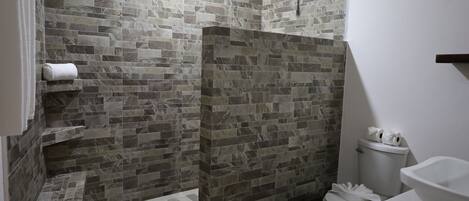 A bathroom with a shower, toilet, and sink.