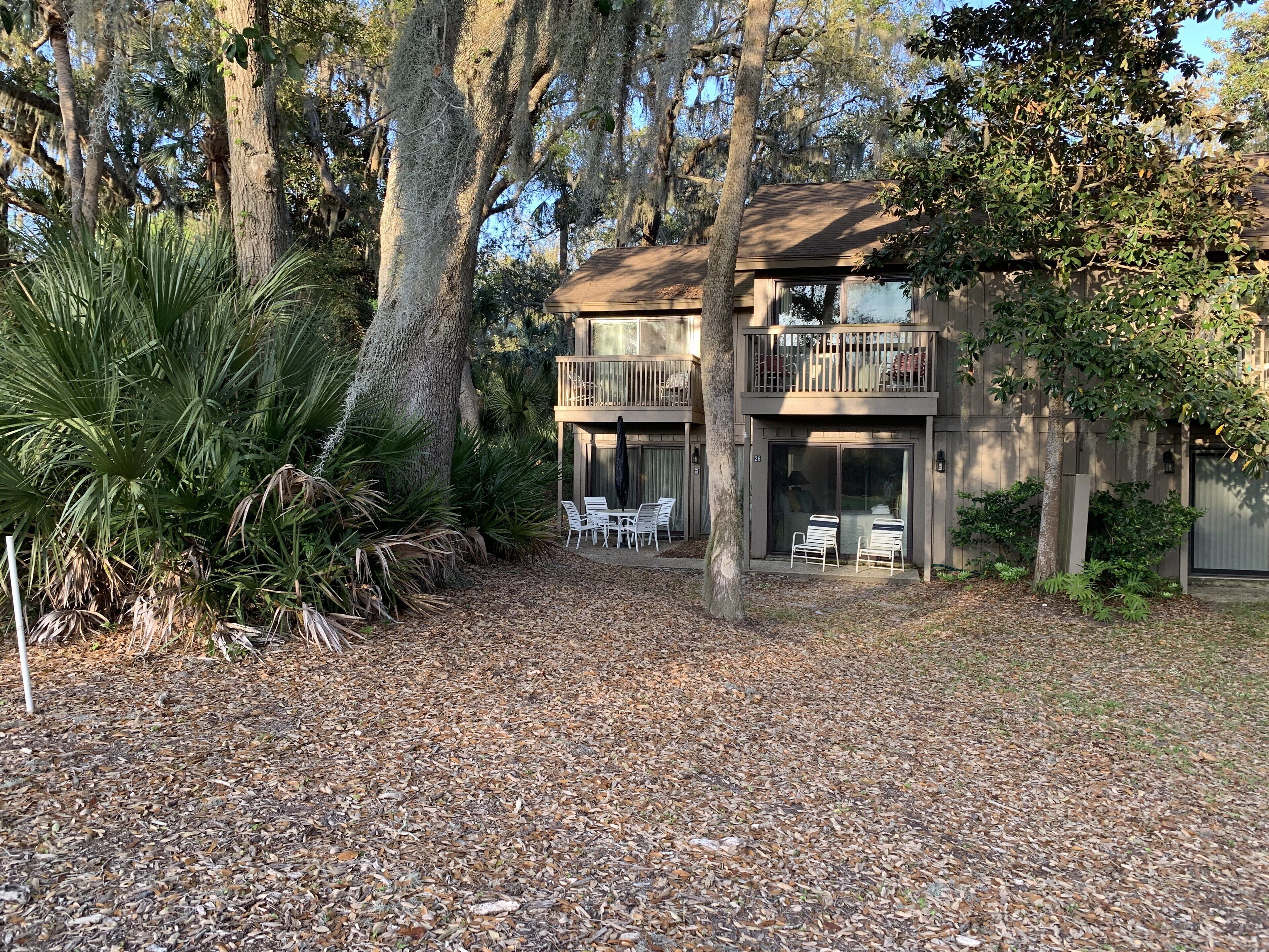 A two-story building with a balcony and a patio area.