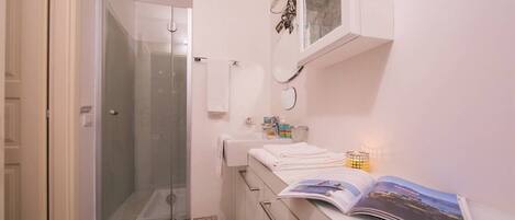 Chuveiro, secador de cabelo, toalhas de banho, sabonete