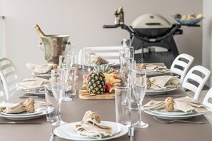 Ein Esstisch, gedeckt mit Tellern, Besteck, Gläsern und einer Ananas als Mittelstück.