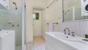 Ein Badezimmer mit Dusche, Waschbecken und Spiegel.