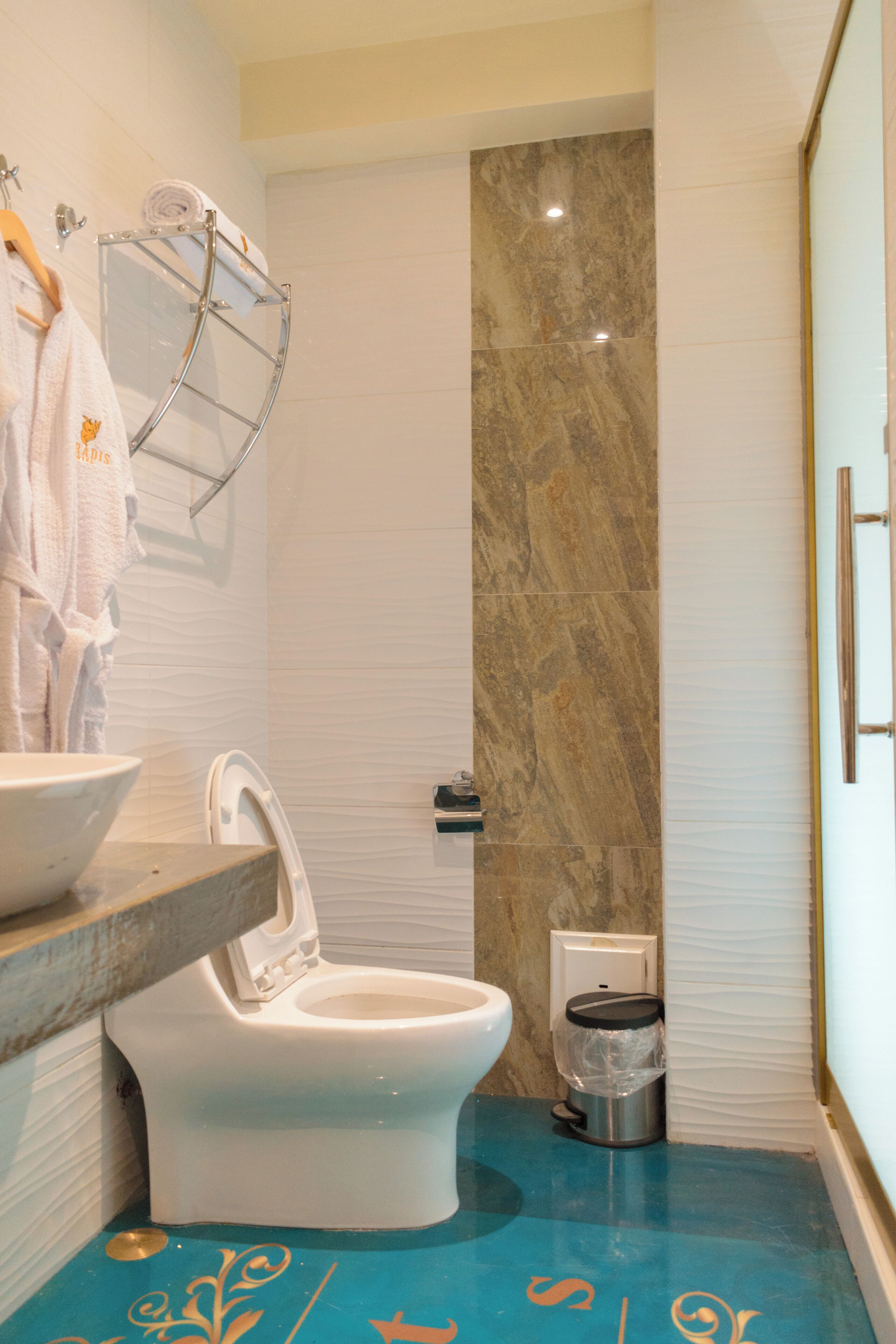 A bathroom with a toilet, sink, and towel rack.