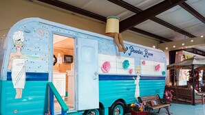 A colorful trailer with a shower and a sign reading "Shower Room." - Lone Star Glamp Inn (Round Top)