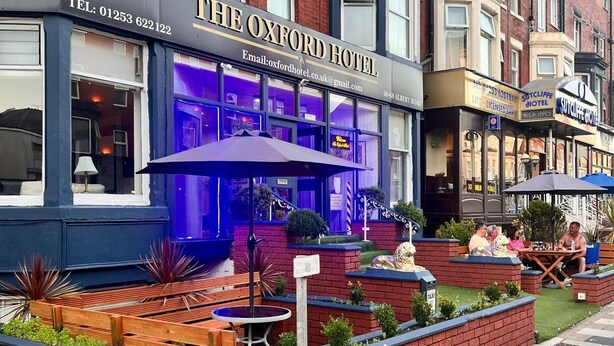 The Oxford Hotel with outdoor seating and a lion statue.