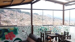 A high-ceilinged room with large windows overlooking a cityscape. - Marvelous Plaza (Cusco)