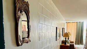 A hallway with a brick wall, a wooden door, and a patterned rug. - ~Waikiki~ LOWEST RATES IN AREA ~ 2 Bedroom ~ Fully Furn ~ Blocks to Beach ~ (Honolulu)