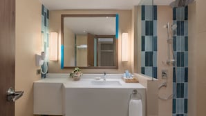 A modern bathroom with a large mirror, a sink, a shower, and a towel rack. - Henann Tawala Resort (Panglao)
