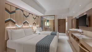 A modern hotel room with two beds, a glass desk, and a flat-screen TV. - Henann Tawala Resort (Panglao)