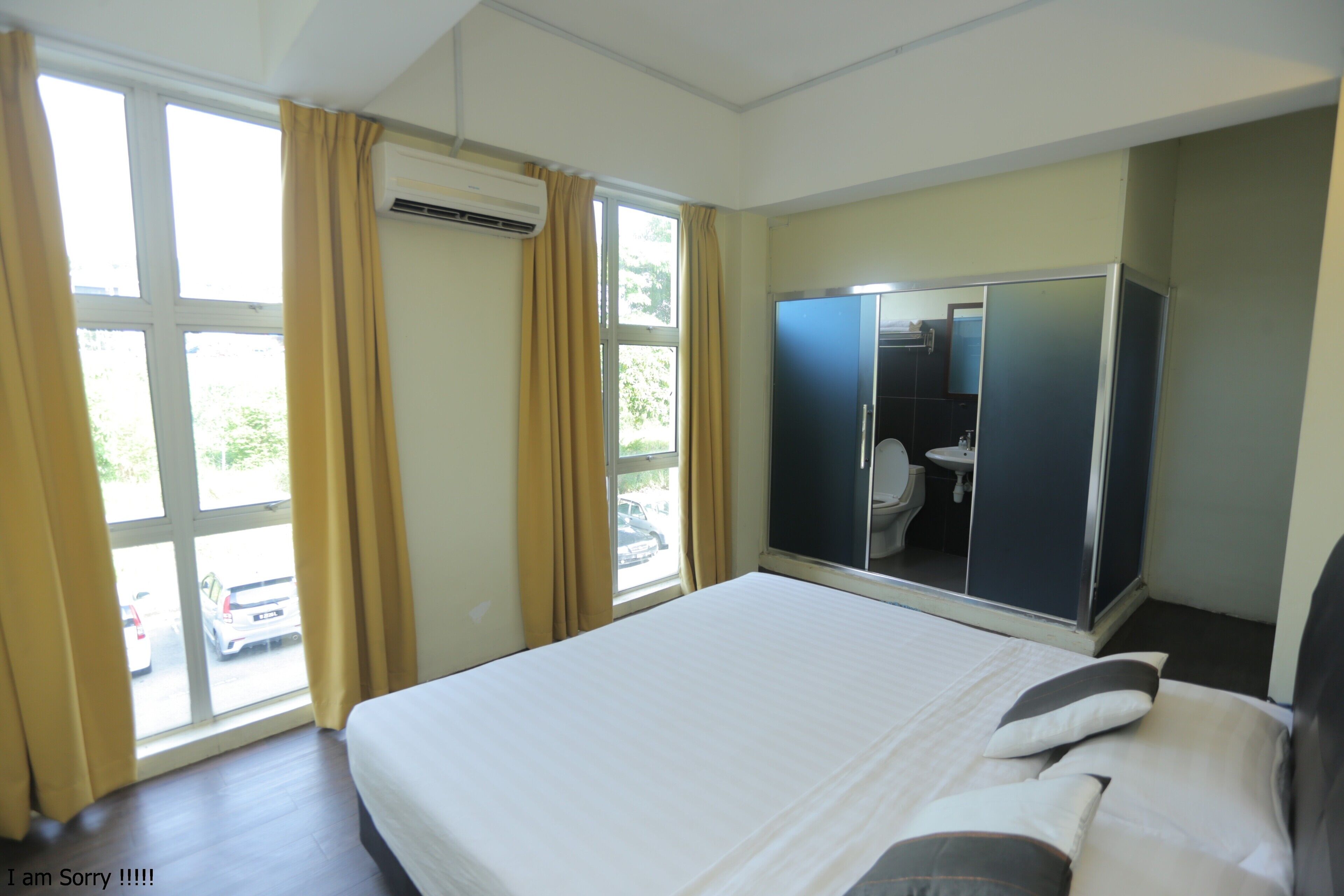 Habitación de hotel con cama, armario, baño y vistas al exterior.
