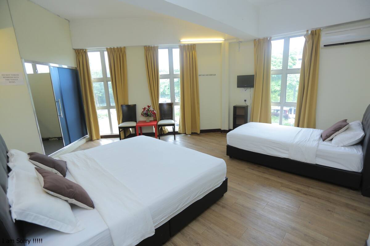 Een hotelkamer met twee bedden, een bureau, een stoel en een televisie.