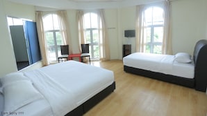 Een hotelkamer met twee bedden, een televisie, een bureau en een stoel.
