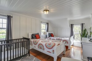 A bedroom with a crib, two beds, a dresser, and a window with curtains. - Hot tub relaxing retreat. Large group gatherings! Business travel. (Kenosha)