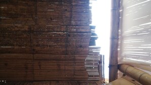 A wooden interior with a bamboo floor and a wooden wall. - Qji Bio Hotel Glamping (Villavieja)