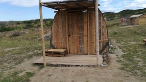A rustic wooden structure with a door and a small wooden platform in front. - Qji Bio Hotel Glamping (Villavieja)
