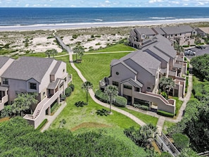 Un quartier résidentiel en bord de mer, avec des maisons modernes, une plage et une promenade en bord de mer.