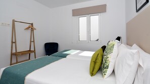 Une chambre avec un lit, une échelle en bois, une fenêtre et une chaise noire.