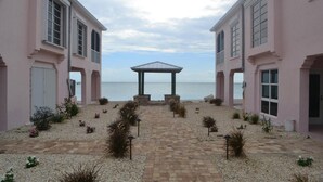 Ein Gebäude mit einem gepflasterten Weg, der zu einem Pavillon mit Blick auf das Meer führt.