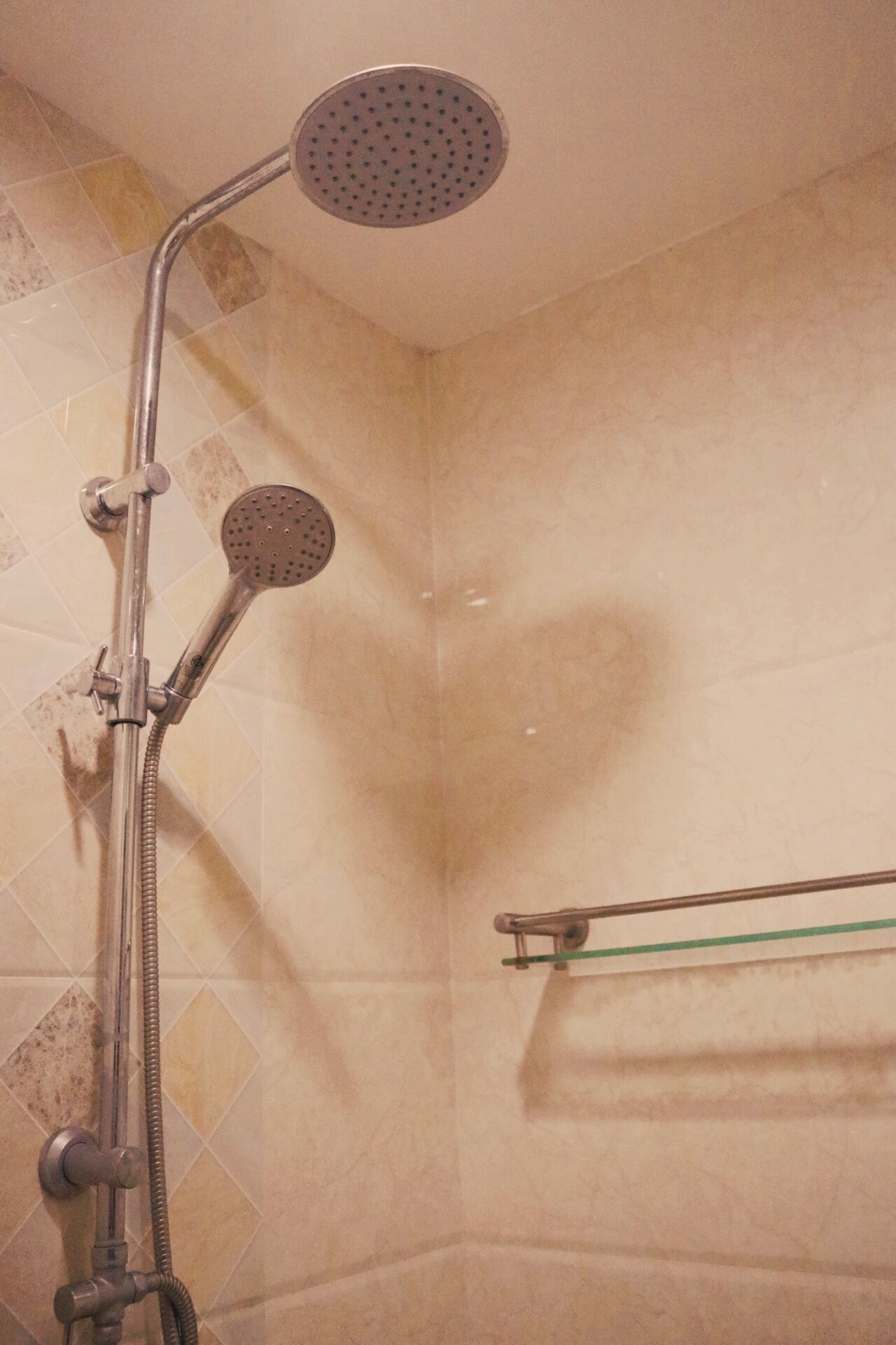 A shower with a handheld showerhead and a wall-mounted faucet.