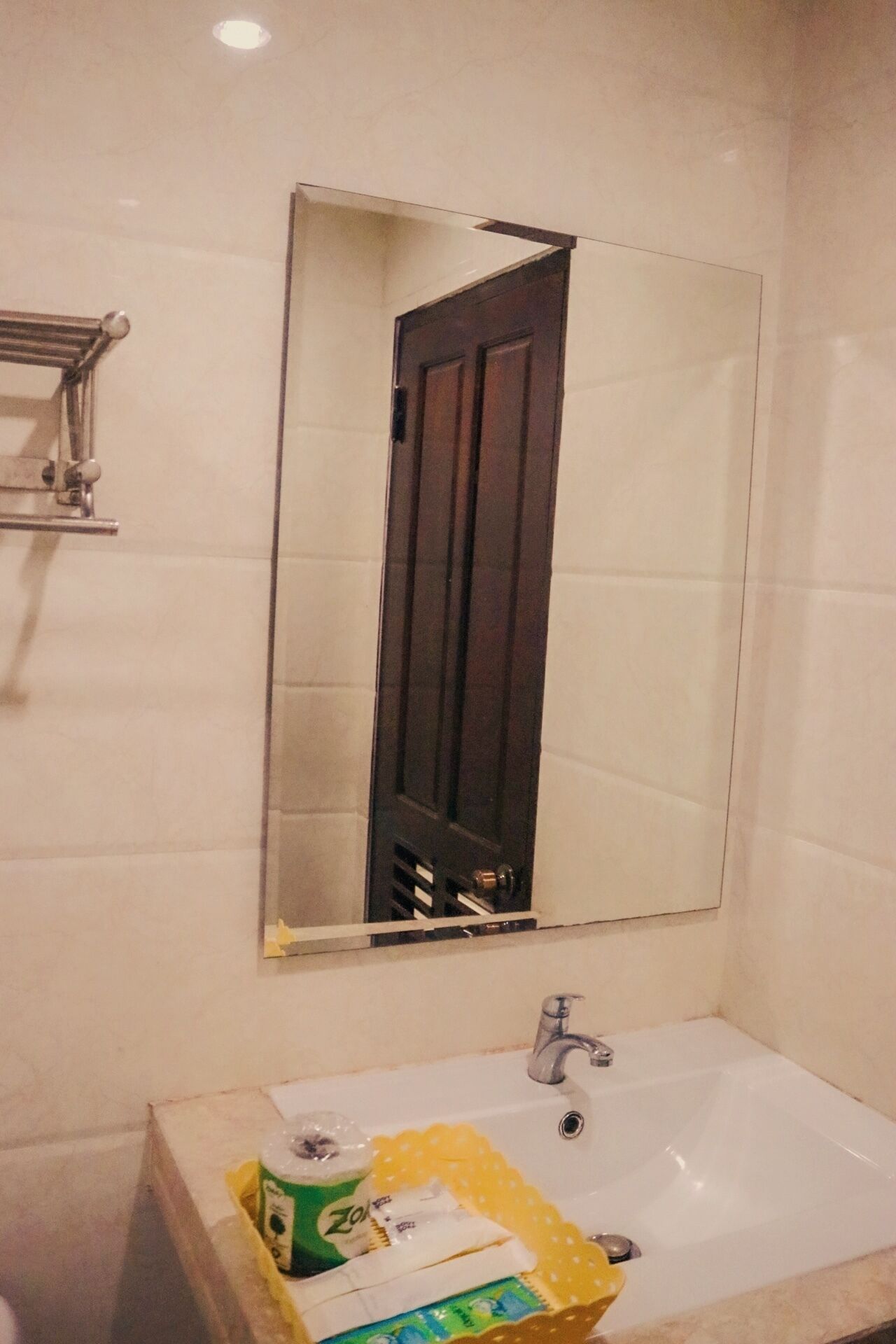 A bathroom with a white sink, a mirror, and a door.