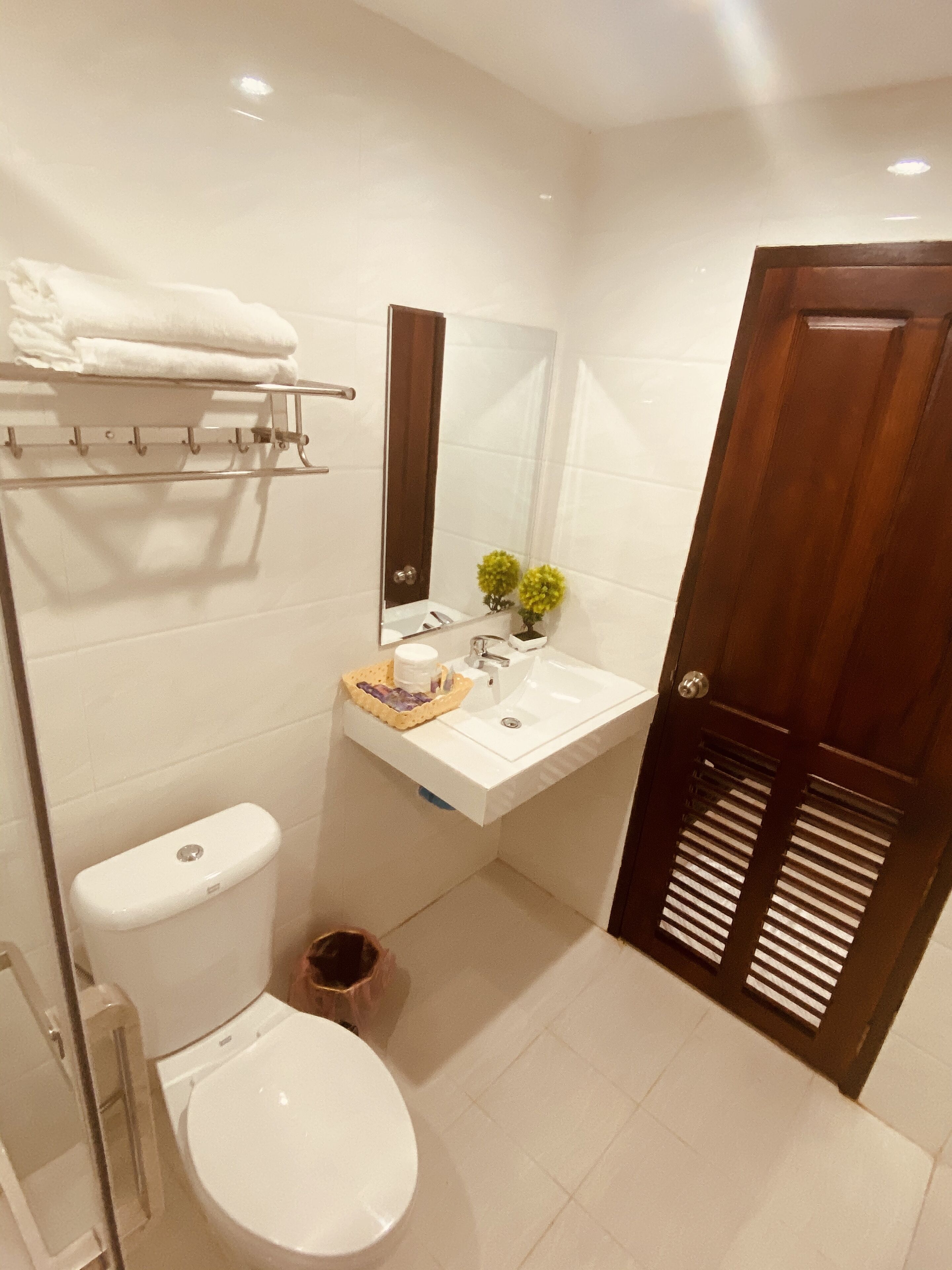 Un baño moderno con inodoro, lavamanos y espejo.