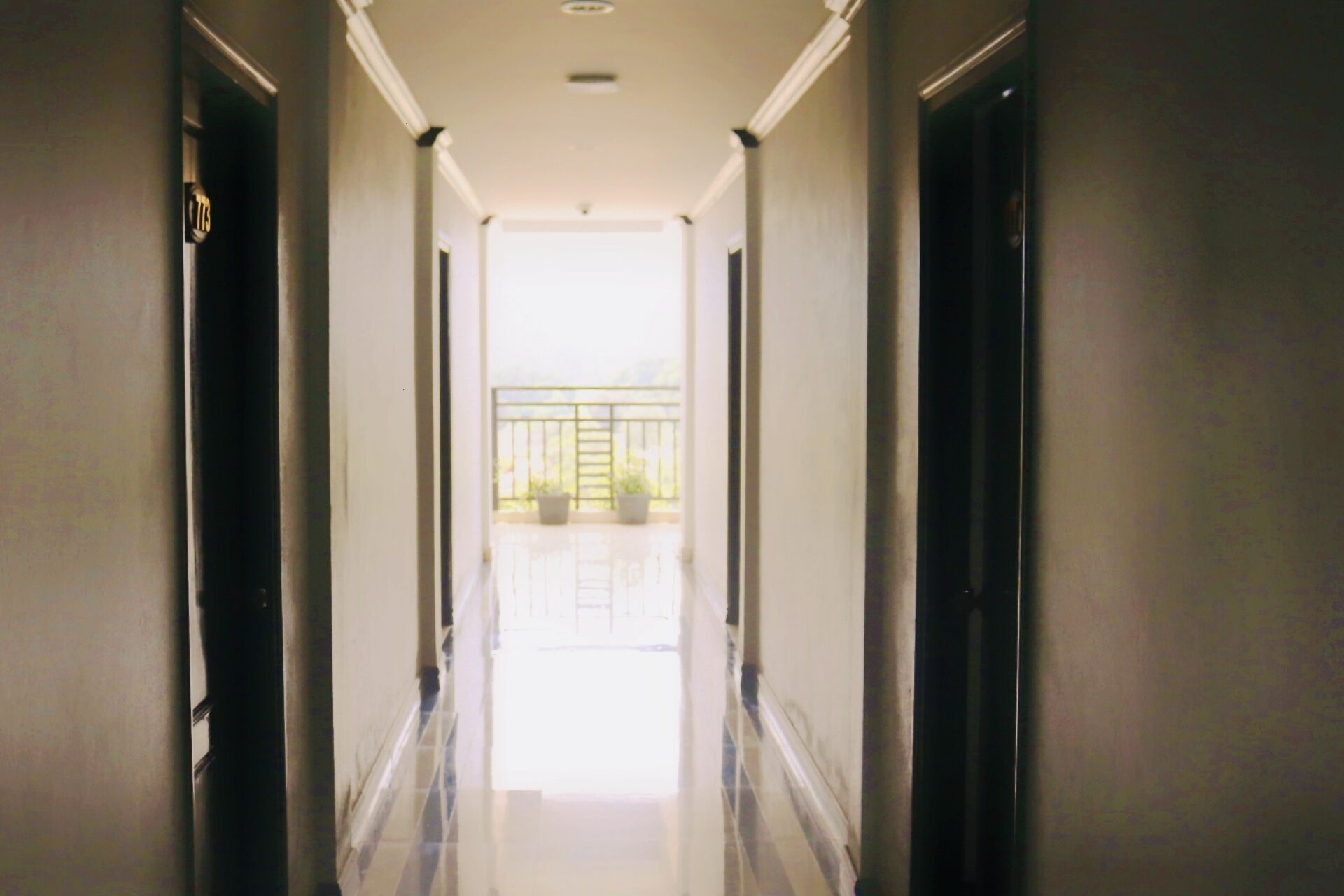 A corridor with a view of a balcony at the end.