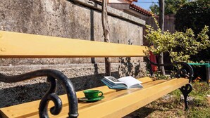 A wooden bench with a green cup and an open book. - Holiday home mit Terrasse und Klimaanlage (Petehi)