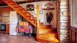 A kitchen with a wooden staircase leading to a stone wall. - Holiday home mit Terrasse und Klimaanlage (Petehi)