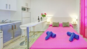 A room with a bed, a small table, a sink, and cabinets. - Muralla Roja by Interhome (Calpe/Calp)