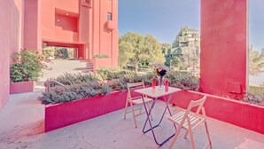 A modern building with pink walls and a patio area with a table and chairs. - Muralla Roja by Interhome (Calpe/Calp)