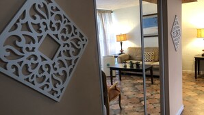 Ein Zimmer mit wandfälligem Muster, einer Couch, einem Couchtisch und einem Sessel.