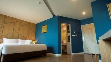 Una habitación de hotel moderna con una cama grande, un panel decorativo de madera y un panel decorativo azul.