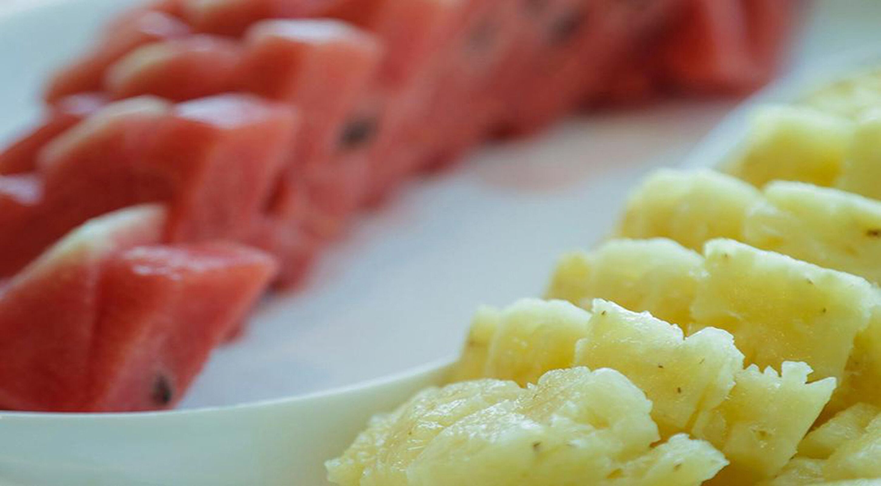 Um prato com melancia em fatias e purê de batatas.