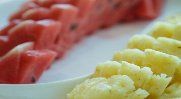 Um prato com melancia em fatias e purê de batatas.