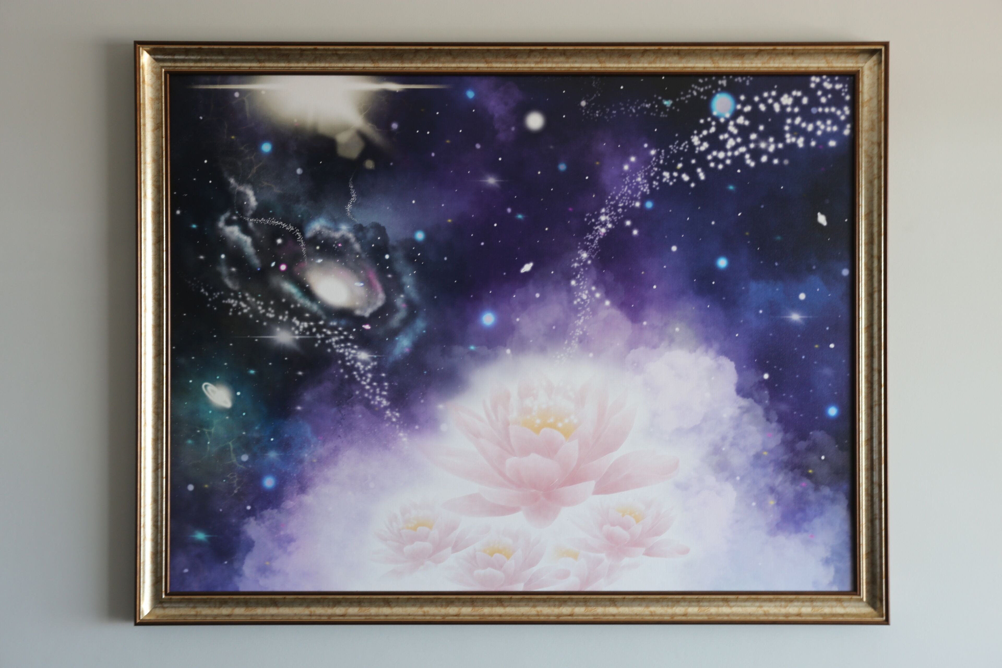 Ein gerahmtes Kunstwerk zeigt eine kosmische Szene, in deren Zentrum ein Lotusblume steht.