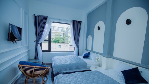 A hotel room with two beds, a television, and a window with curtains. - Rome Hostel (Tuy Hoa)