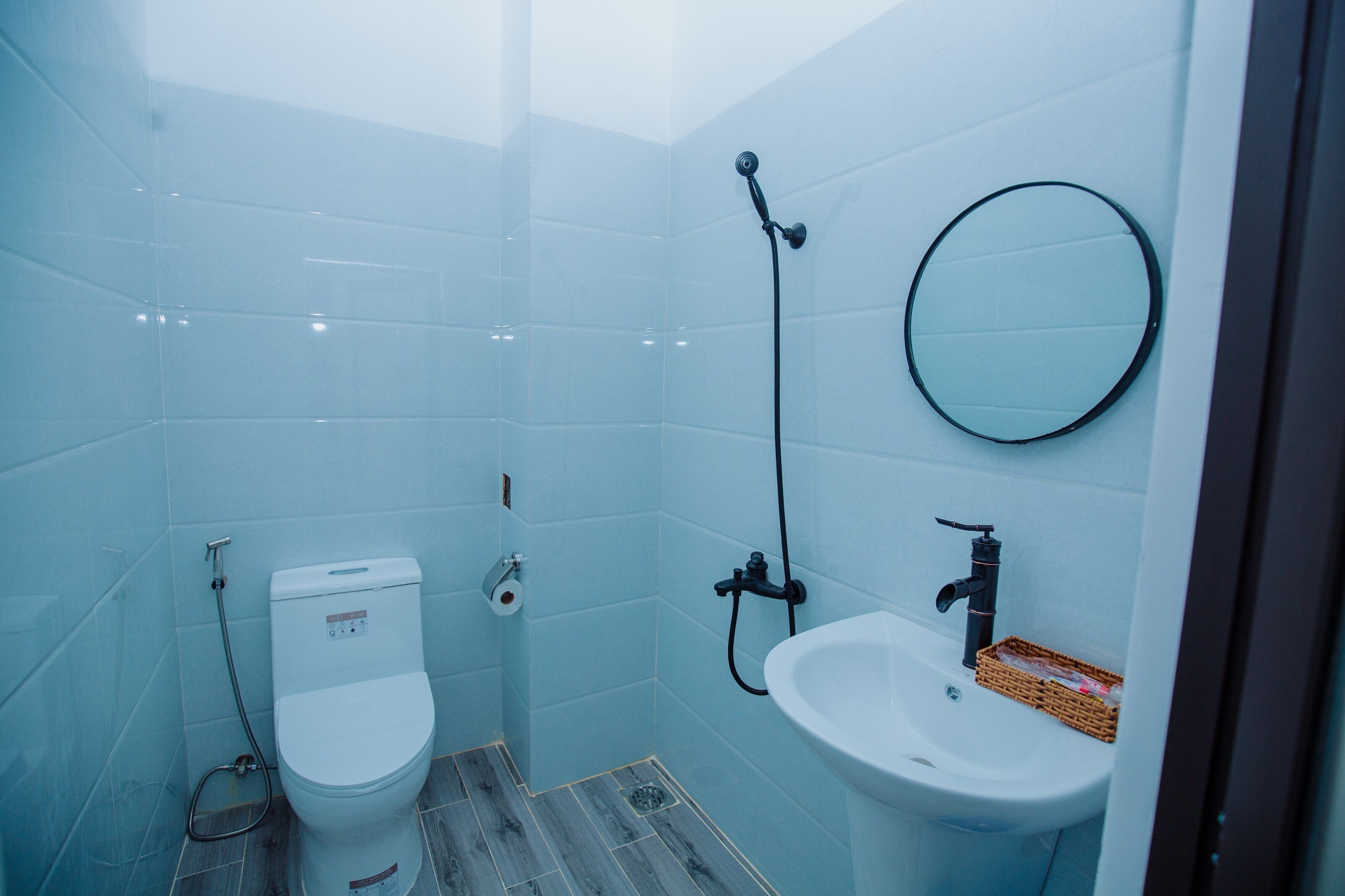 A small bathroom with a toilet, sink, and shower.