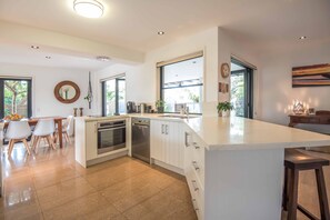 Enjoy meals in the spacious kitchen with a large island, sink, and ample counter space, complemented by sleek cabinetry and a dishwasher.