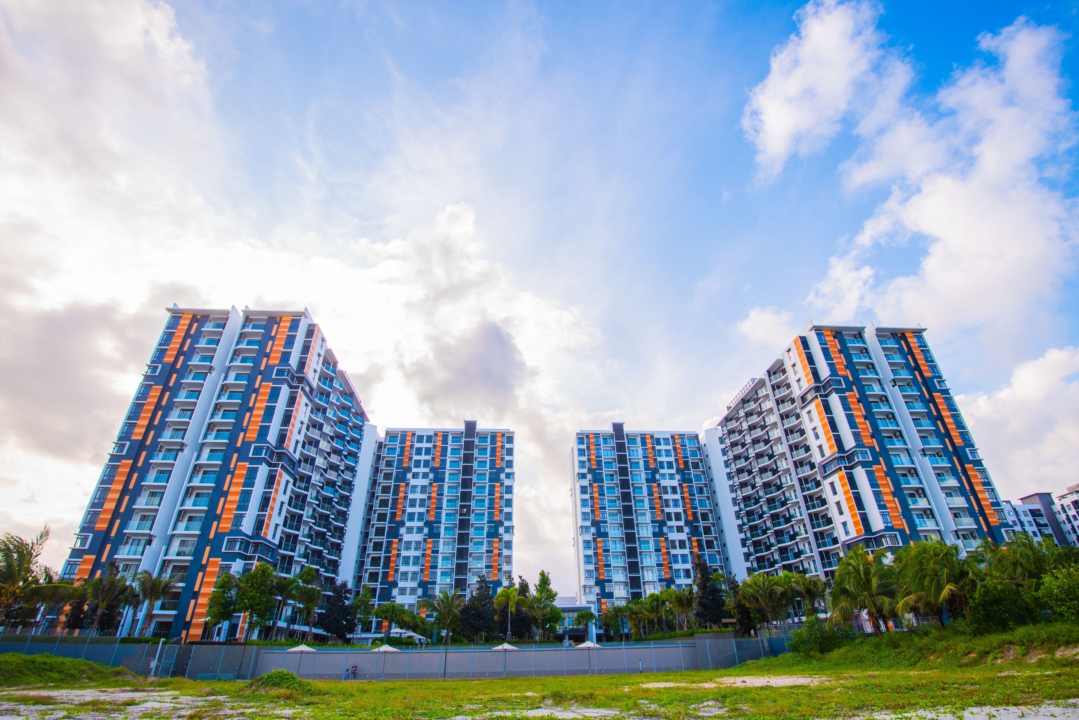 A modern high-rise building with multiple balconies and a clear sky.